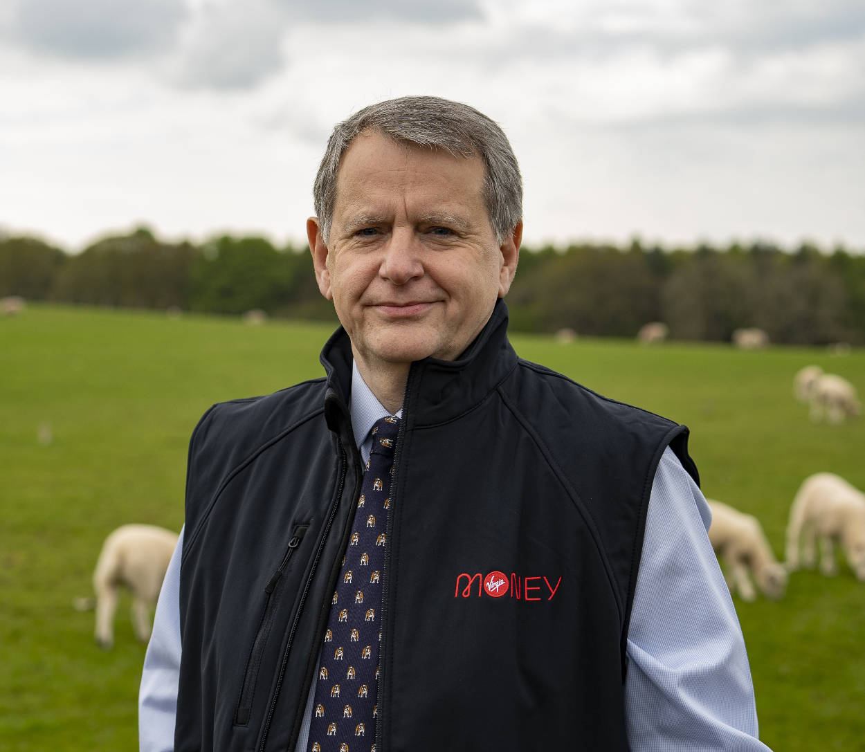 Brian Richardson standing in a field of sheep